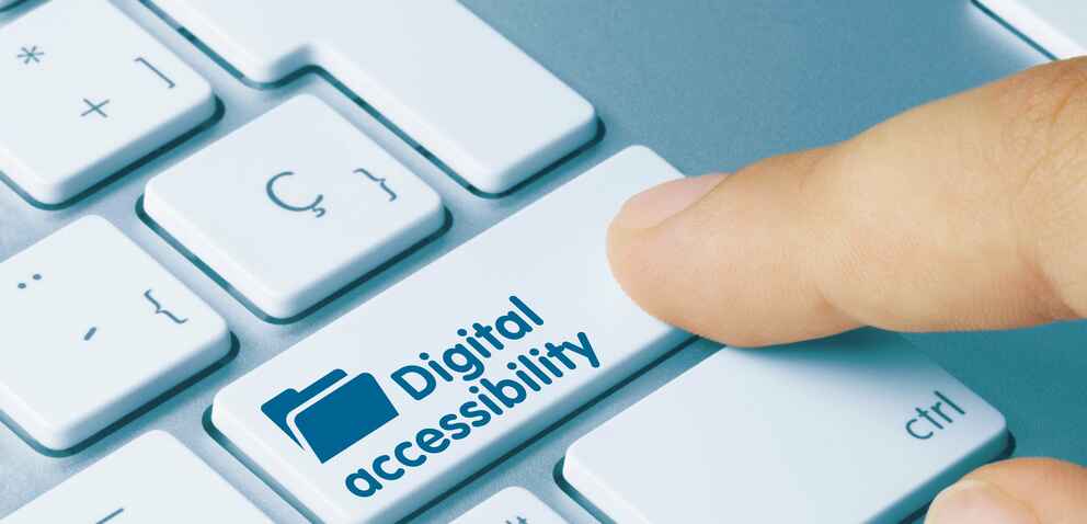Photo of a person pressing a key on a keyboard that is labeled "digital accessibility"